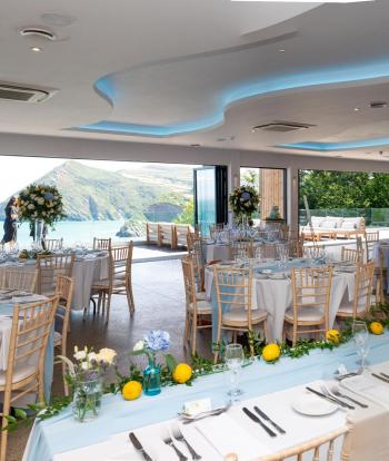 Inside The Venue at Sandy Cove with wedding decorations on tables and sea view