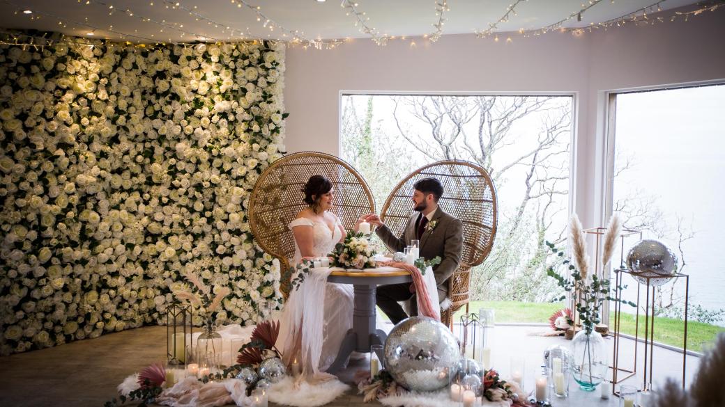 A newly-wed couple inside The Venue at Sandy Cove with decorations for their winter wedding