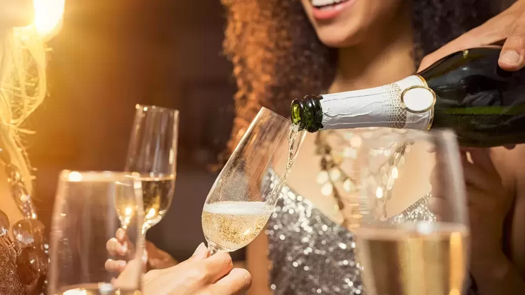 A group of friends sharing a bottle of Champagne at a New Year party