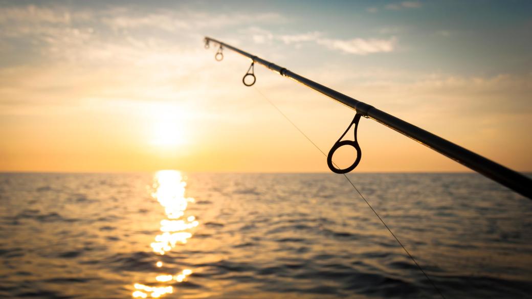 Fishing rod with sea and sunset in the background