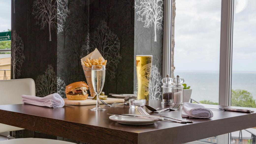 Meals and drinks set on a window table in the Cove Restaurant at Sandy Cove Hotel