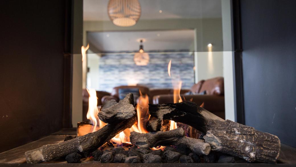 The fireplace in Sandy Cove Hotel's bar lounge area with seating seen behind