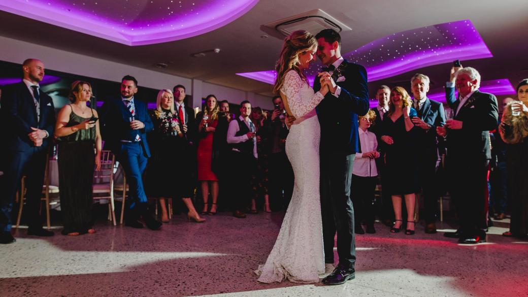 A bride and groom sharing their first dance with family at Sandy Cove's The Venue