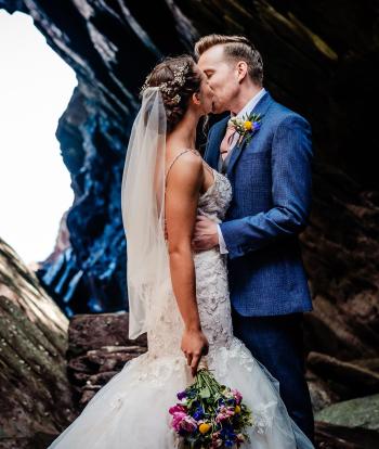 Newly wed couple Ellie and Joe sharing a kiss on Broadsands Beach after their wedding at Sandy Cove Hotel
