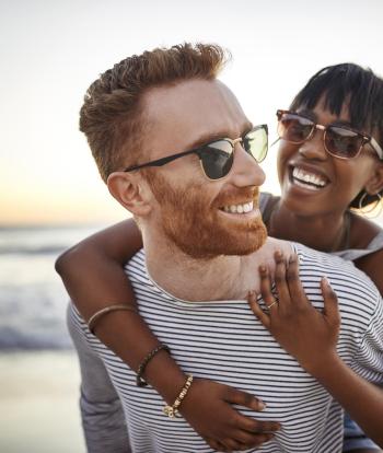 A happy, smiling couple on the beach at sunset