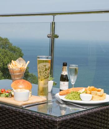 Food and Drink served on the terrace outside of the Cove Restaurant with a view of the bay at Sandy Cove Hotel