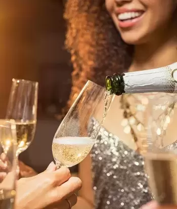 A group of friends sharing a bottle of Champagne at a New Year party