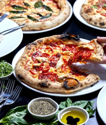 A selection of pizzas on a table in one of Sandy Cove Hotel's restuarants