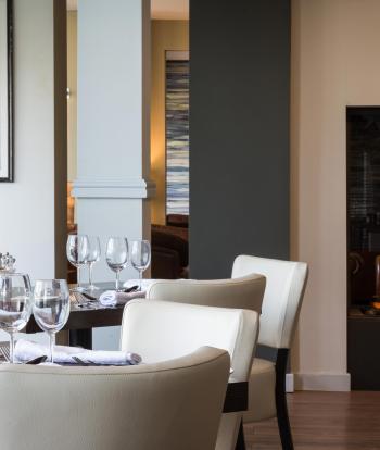 Tables and chairs set for diners inside the Cove Restaurant at Sandy Cove Hotel