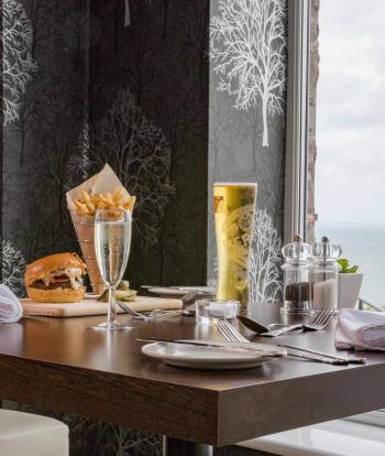 Meals and drinks set on a window table in the Cove Restaurant at Sandy Cove Hotel
