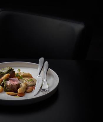 A plate of food with cutlery on a table inside the Seacliff Restaurant at Sandy Cove