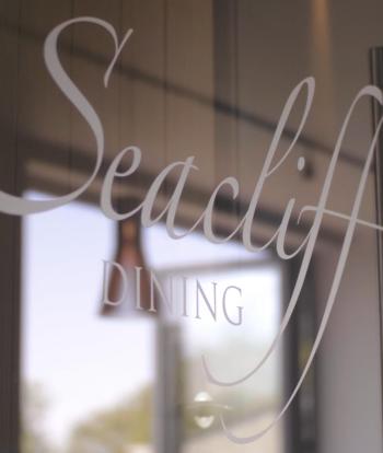 The door to the Seacliff Restaurant at Sandy Cove Hotel with the logo on the glass