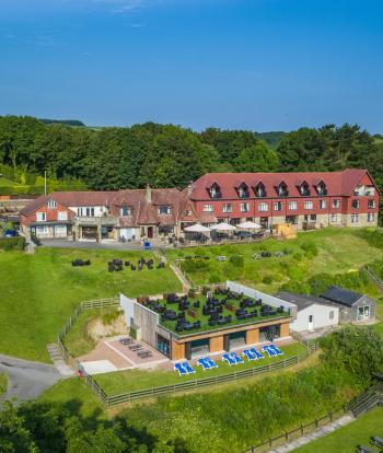 A view over Sandy Cove Hotel and its terrace with the surrounding countryside