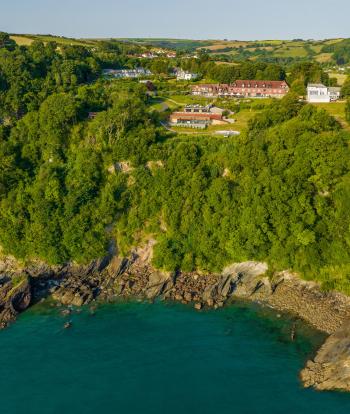 An aerial view of Sandy Cove Hotel and the surrounding countryside and sea