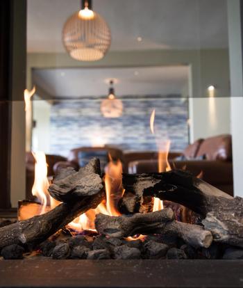 The fireplace in Sandy Cove Hotel's bar lounge area with seating seen behind