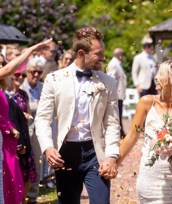 Guests throwing confetti over a bride and groom at Sandy Cove Hotel's the Venue