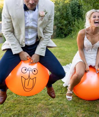A bride and groom on spacehoppers on their wedding day at The Venue