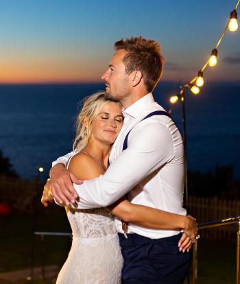 A bride and groom hugging outside The Venue at Sandy Cove Hotel at the end of their wedding day