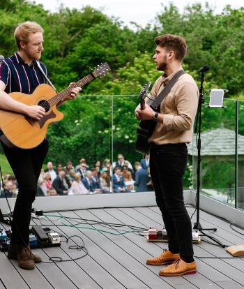 A wedding band playing to guests from the deck of The Venue at Sandy Cove Hotel