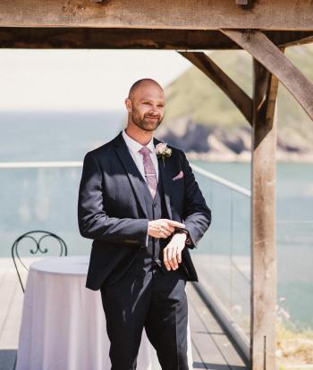 A groom checking his watch under the wedding gazebo at Sandy Cove Hotel
