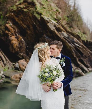 A bride and groom sharing a kiss on Broadsands Beach near Sandy Cove Hotel on their wedding day