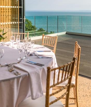 Tables and chairs set up for a Wedding reception inside The Venue at Sandy Cove Hotel