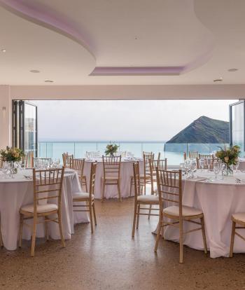 The inside of The Venue at Sandy Cove Hotel with tables and chairs ready for a wedding reception