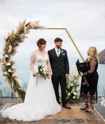 A bride and groom taking their vows at an intimate winter wedding on the deck at The Venue, Sandy Cove Hotel