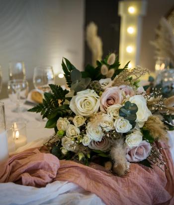 The bride's bouquet lying on a table on wintery decorations inside The Venue, Sandy Cove