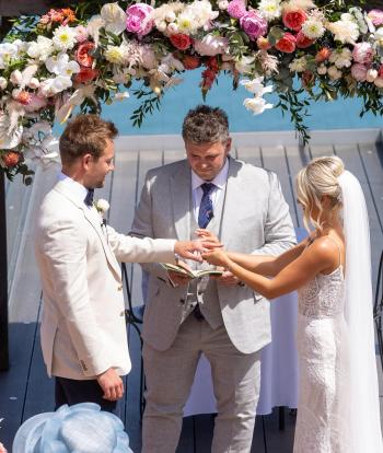 Wedding ceremony outside by the arbour with the view behind at the Sandy cove hotel