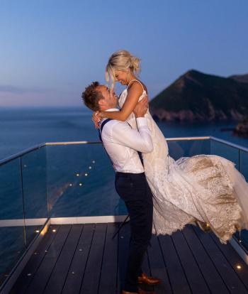 Bride and groom standing outside with beautiful view behind them