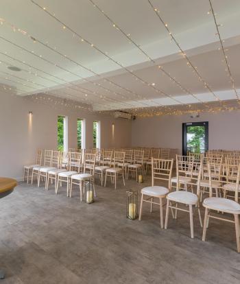 Chairs set up for wedding guests on either side of the aisle in the Ceremony Room at Sandy Cove Hotel