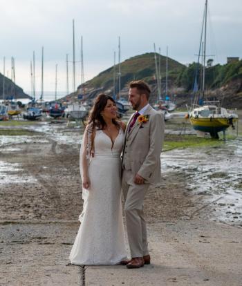 Bride and groom on the shore below Sandy Cove Hotel