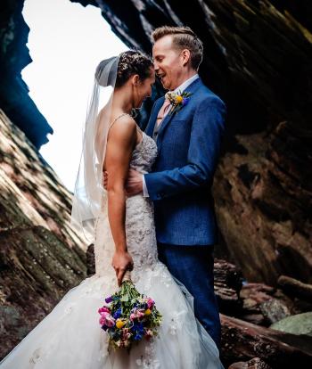 Bride and groom on the shore below Sandy Cove Hotel