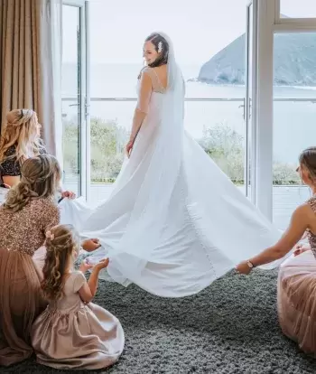Bridesmaids helping the bride get ready on her wedding day at Sandy Cove Hotel