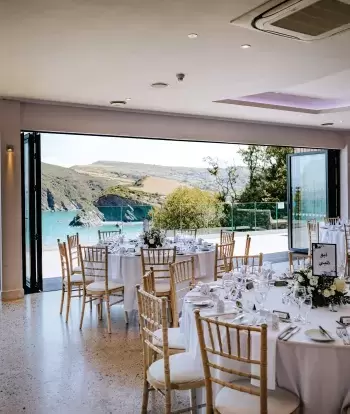 The view from inside The Venue at Sandy Cove Hotel with tables set for a wedding reception