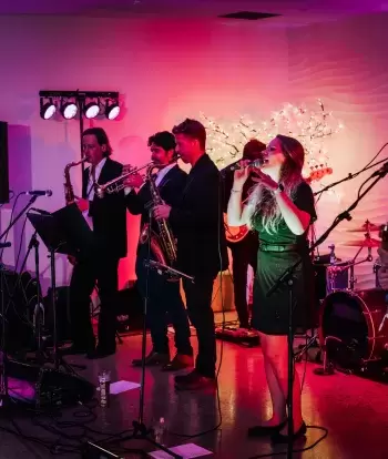A live band playing for wedding guests inside The Venue at Sandy Cove Hotel