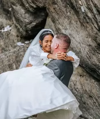 Newly wed couple embrace on the beach