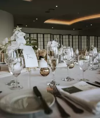 A wedding reception table setting inside The Venue at Sandy Cove Hotel