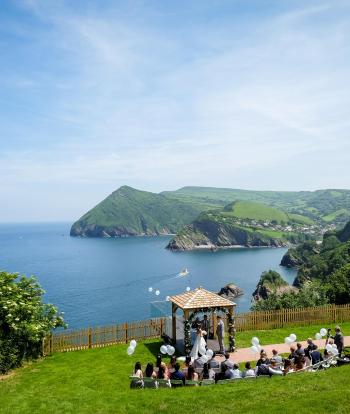 Wedding ceremony outside by the arbour with the view behind at the Sandy cove hotel