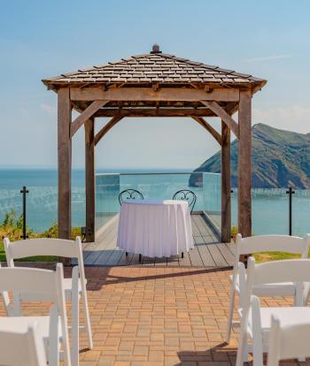 Wedding ceremony outside by the arbour with the view behind at the Sandy cove hotel