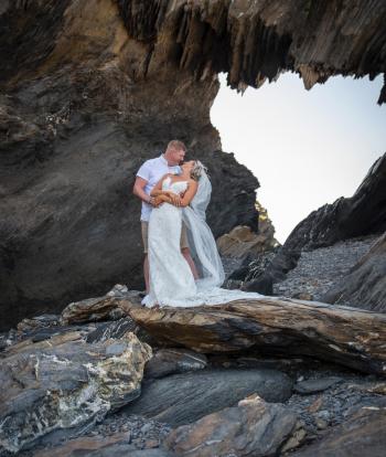 Bride and groom on the shore below Sandy Cove Hotel