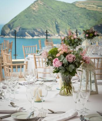 Inside The Venue at Sandy Cove with decorated tables in front of sea view