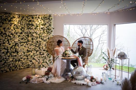 A newly-wed couple inside The Venue at Sandy Cove with decorations for their winter wedding