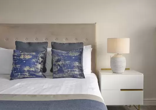 The bed and bedside table in a classic room at Sandy Cove Hotel