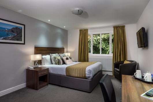 A bed in one of Sandy Cove Hotel's bedrooms with countryside views