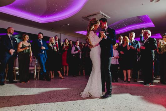 A bride and groom sharing their first dance with family at Sandy Cove's The Venue