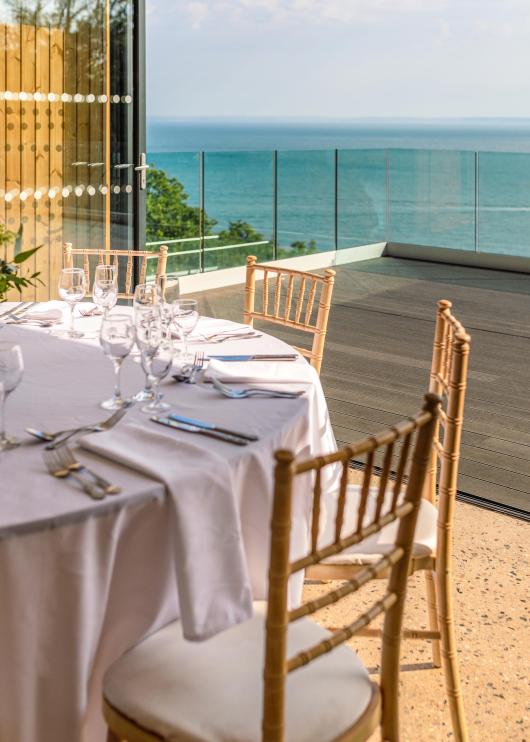 Tables and chairs set up for a Wedding reception inside The Venue at Sandy Cove Hotel