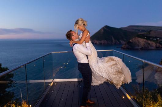 Bride and groom standing outside with beautiful view behind them