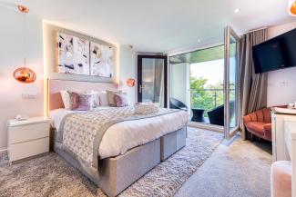 The bedroom and balcony in room 47 at Sandy Cove Hotel